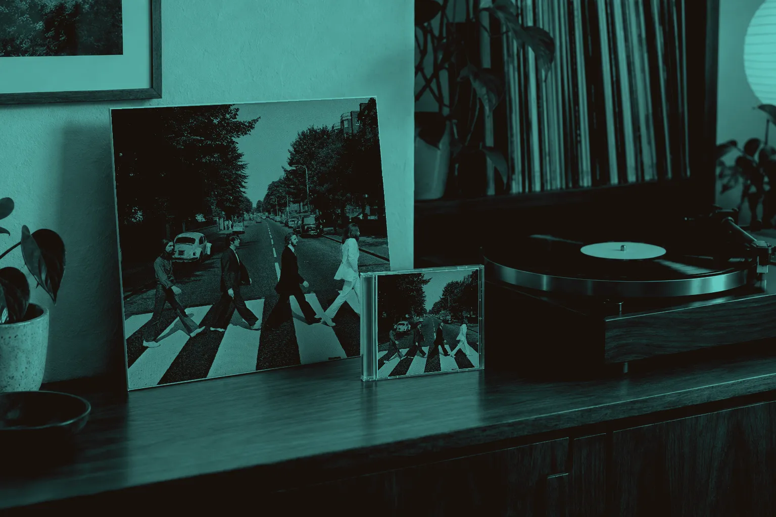 Abbey Road on a vinyl sleeve and CD case beside a turntable in a sunlit listening room.