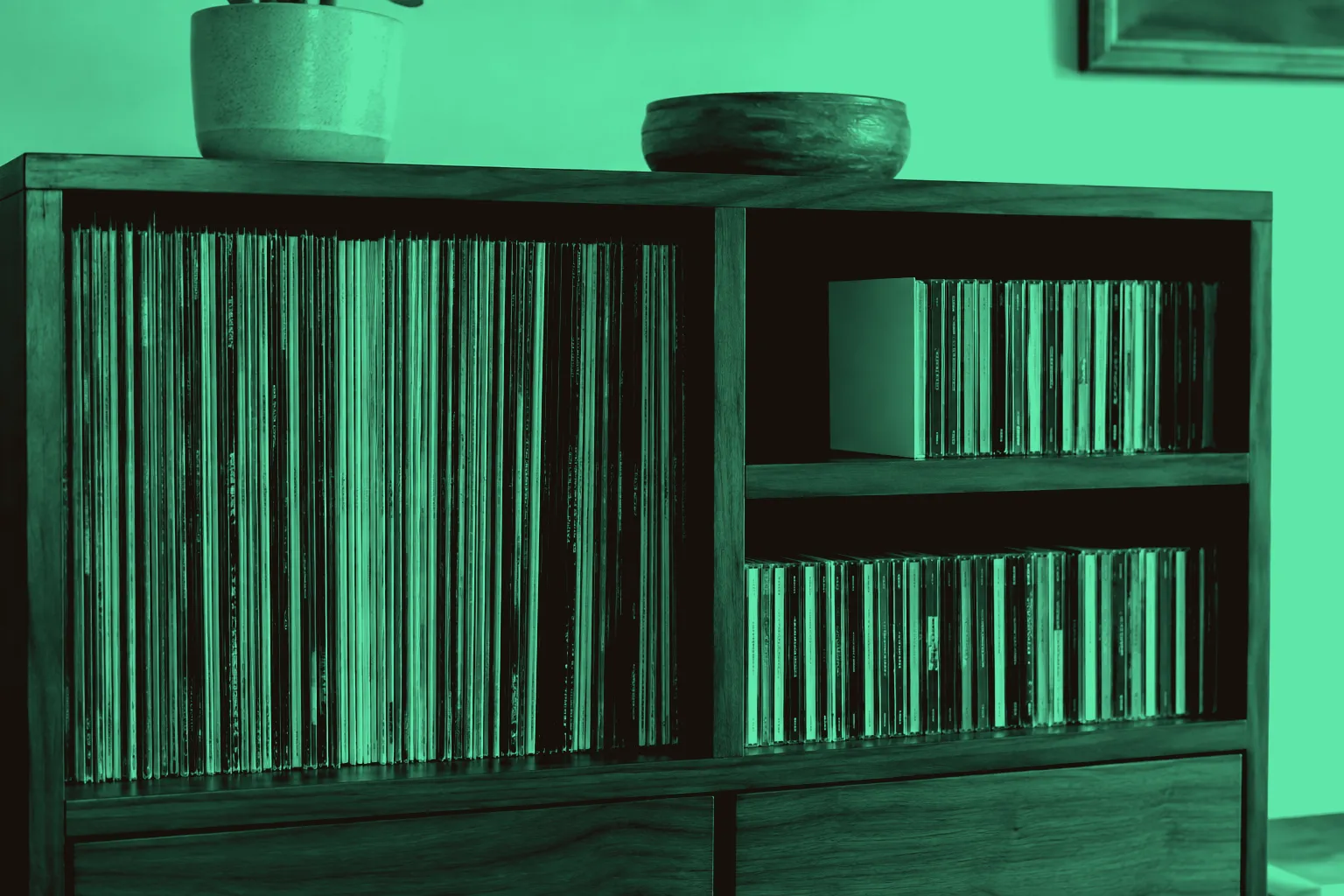 Vinyl records and compact discs arranged upright on separate wooden shelves.