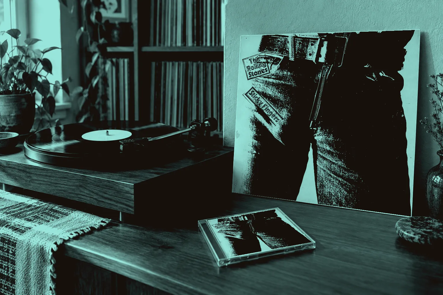 The Sticky Fingers sleeve and a CD case beside a turntable in a sunlit room with records on shelves.