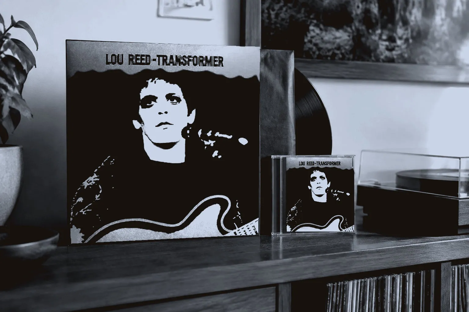 A copy of Transformer on LP and CD standing on a wooden sideboard beside a turntable.